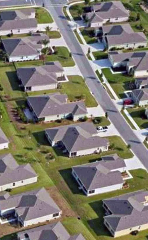 Aerial view of a planned residential estate with homes along a straight road
