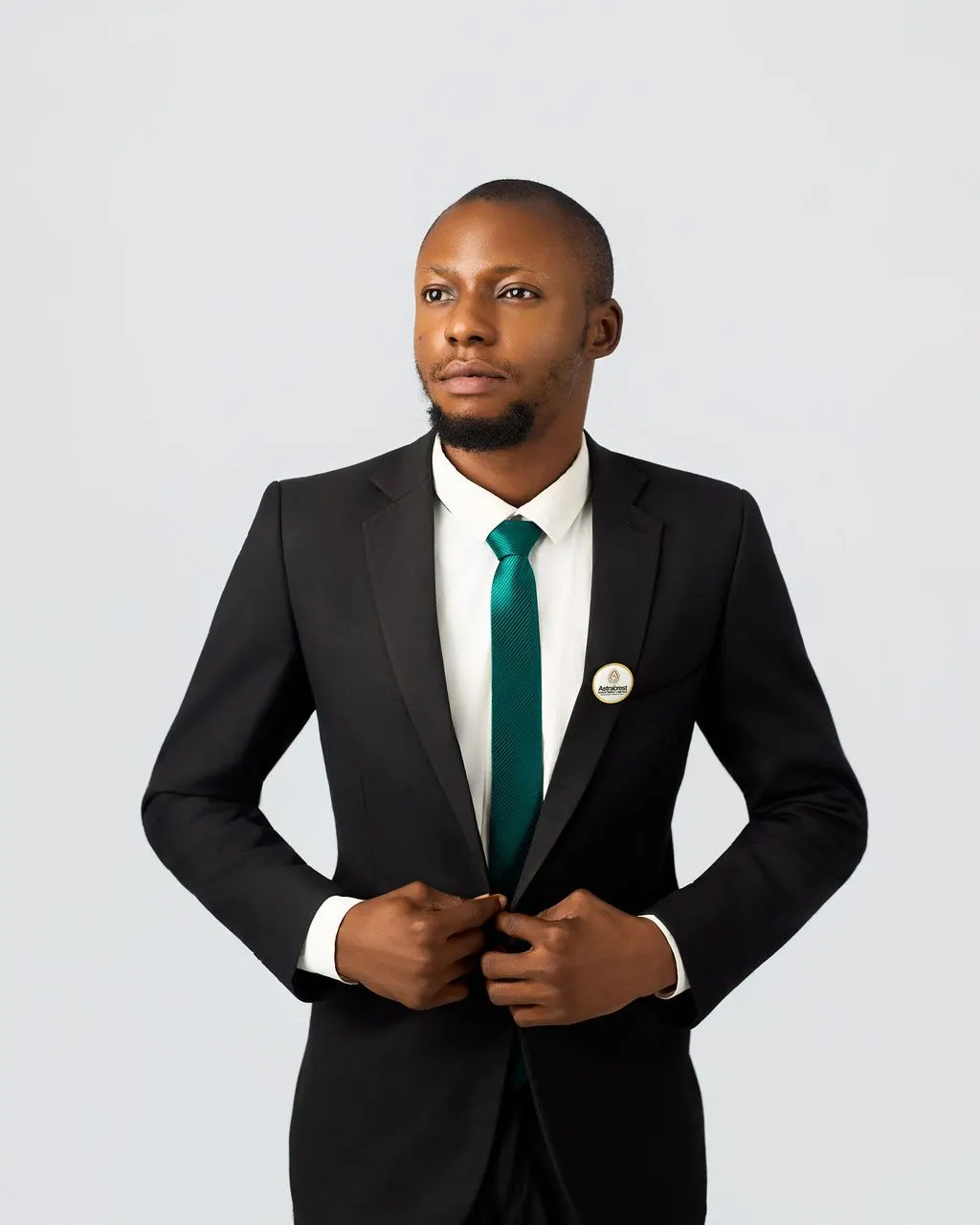 An Astracrest team member in a black suit and green tie