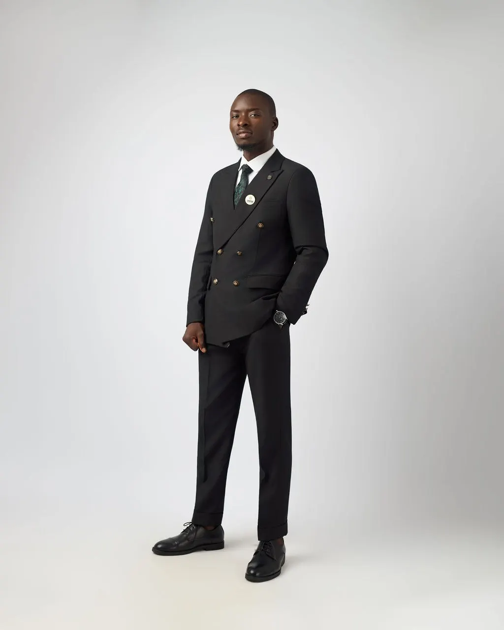 An Astracrest team member in a black suit and green tie
