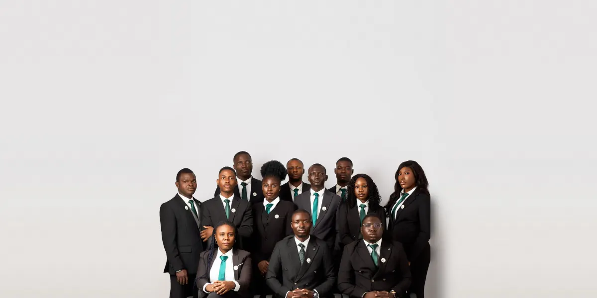 The Astracrest team in black suits and green ties, gathered for a studio group portrait