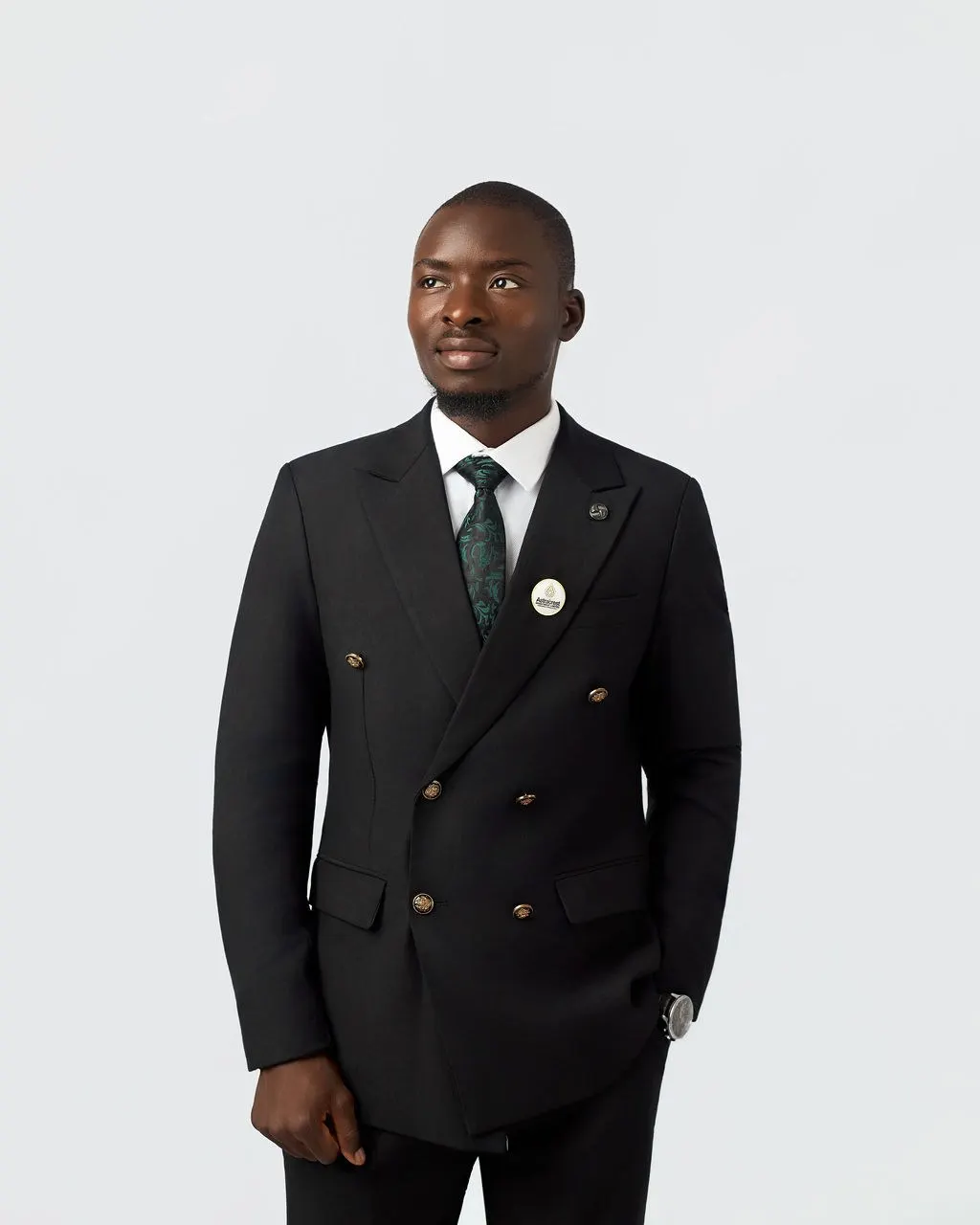 An Astracrest team member in a black suit and green tie